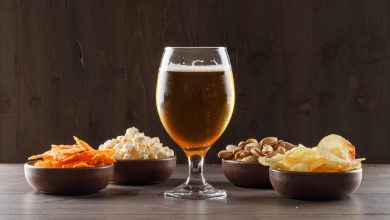 beer with junk food goblet glass wooden table side view